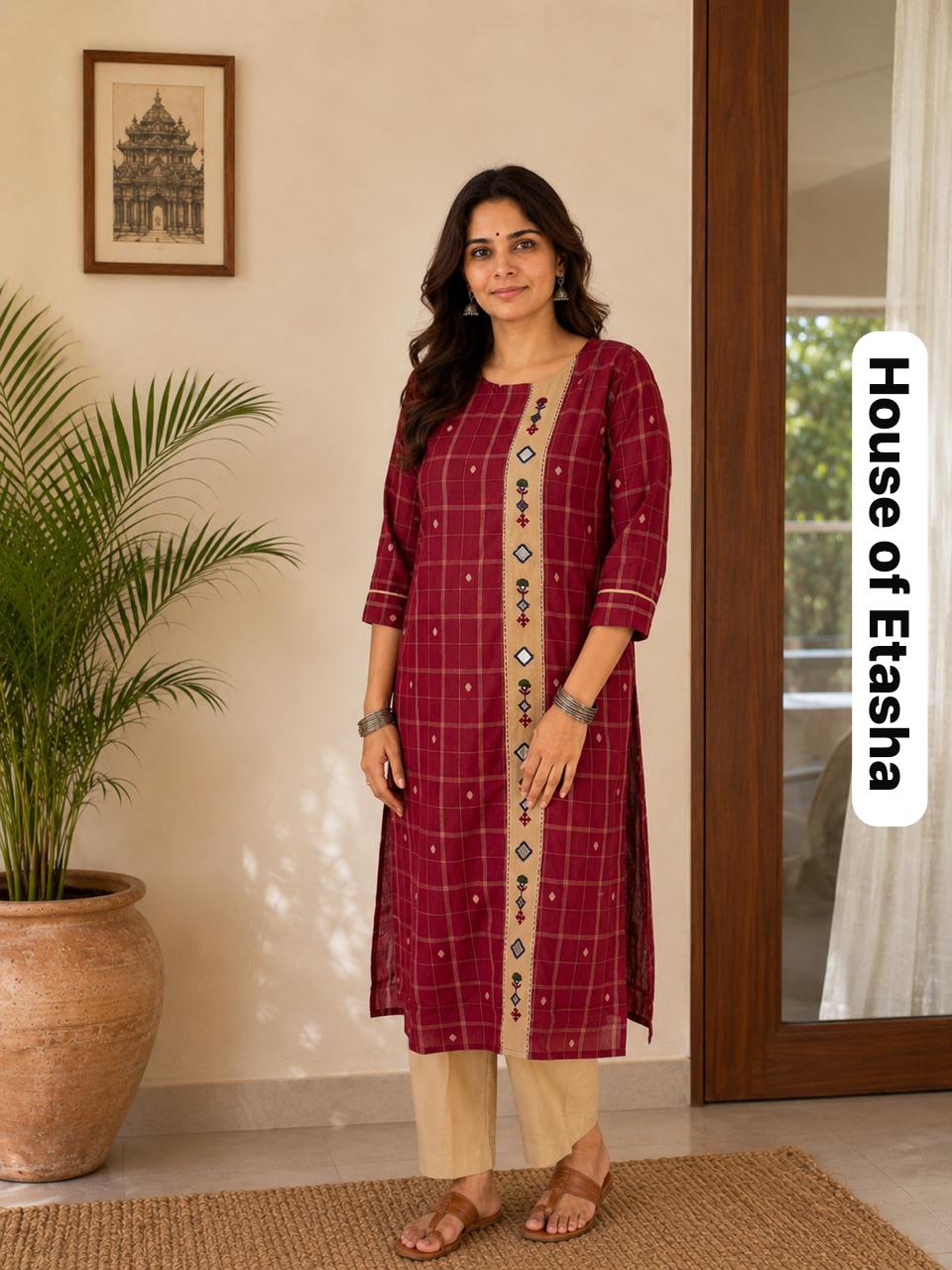 Woman wearing a maroon checkered kurta with beige pants .