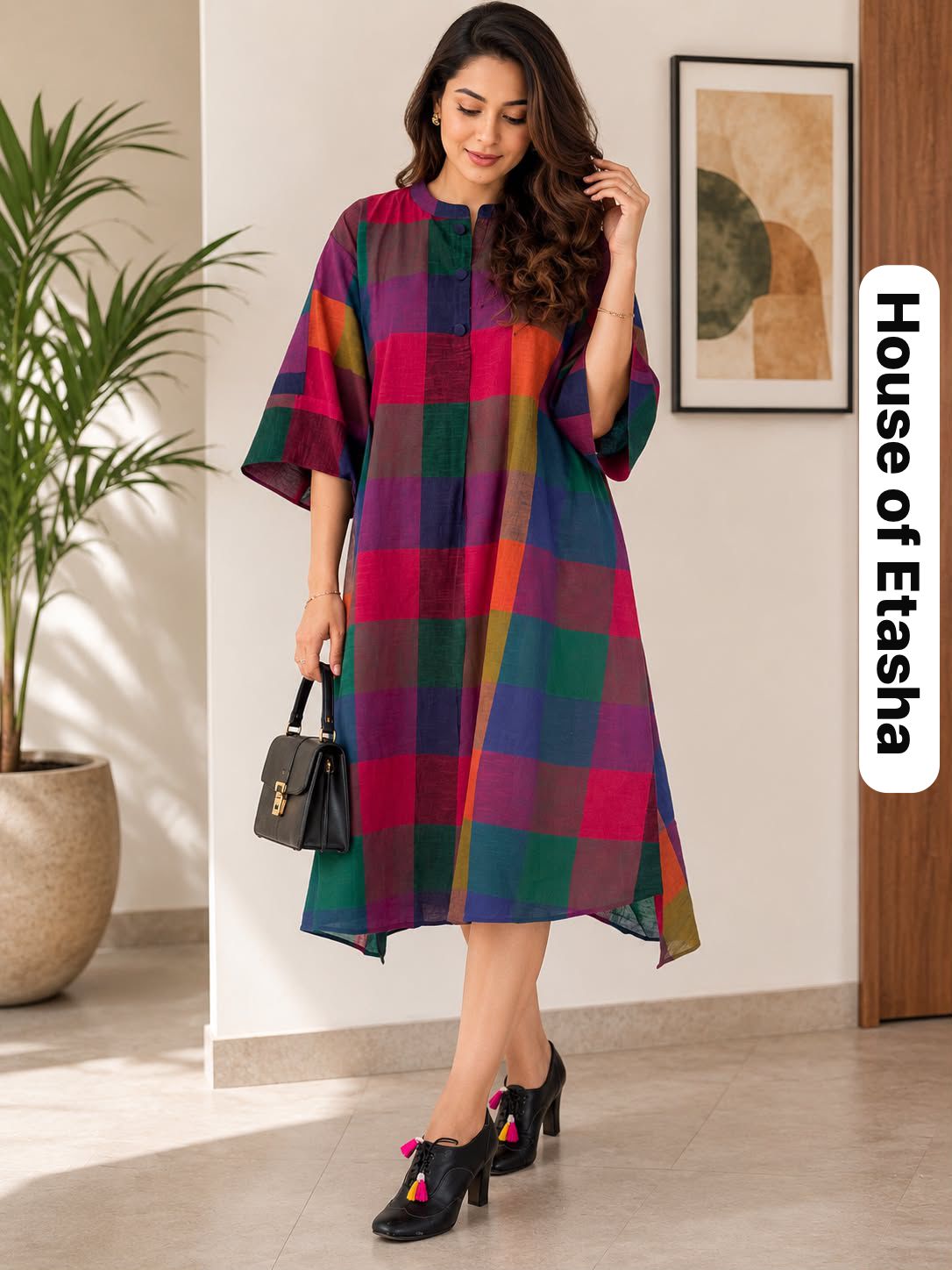 Woman wearing a colorful checkered dress in an indoor setting with 'House of Etasha' branding.